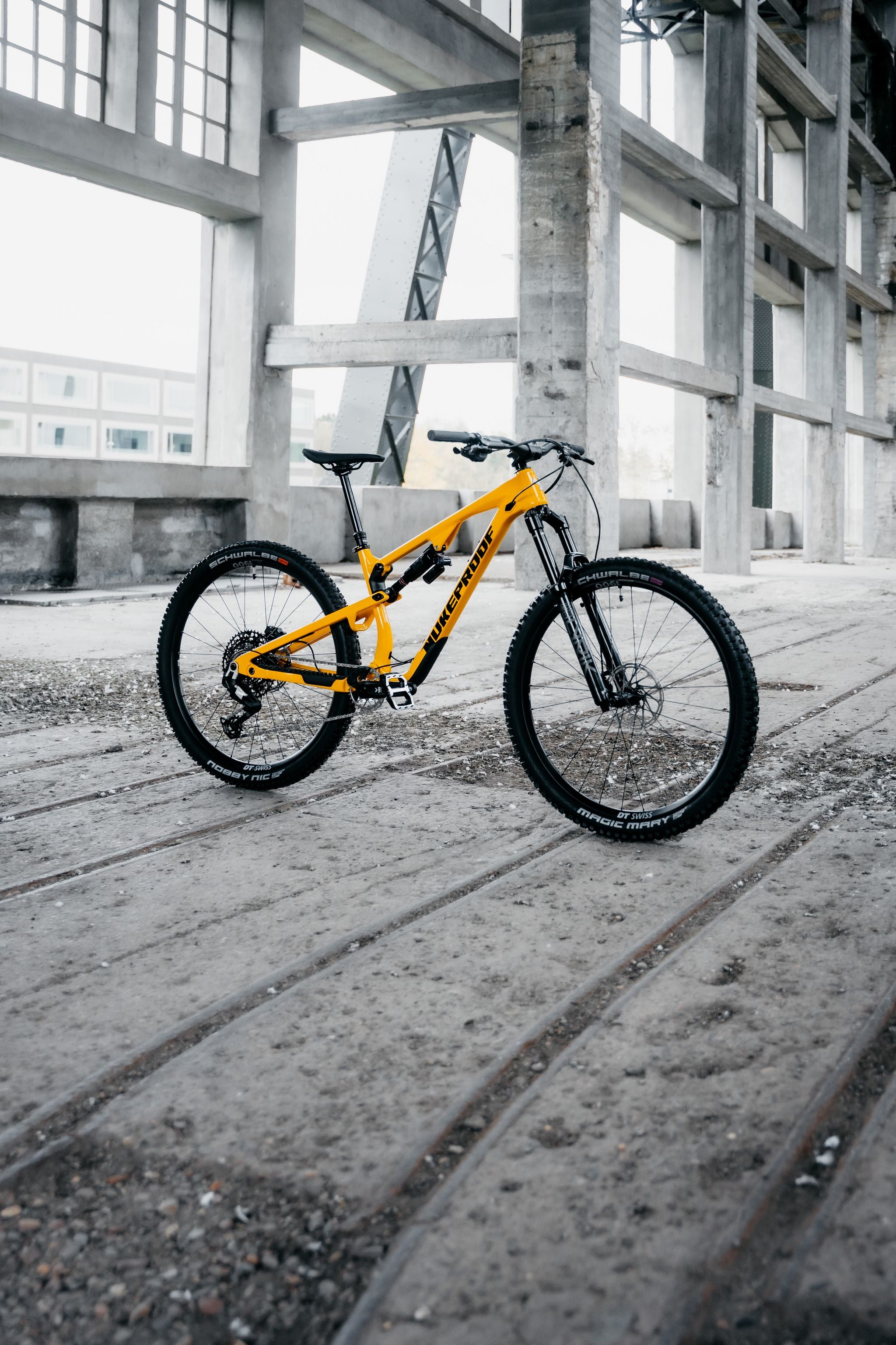 Yellow bicycle on a concrete surface with industrial background