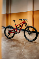 Red mountain bike on a concrete floor with a yellow wall in the background