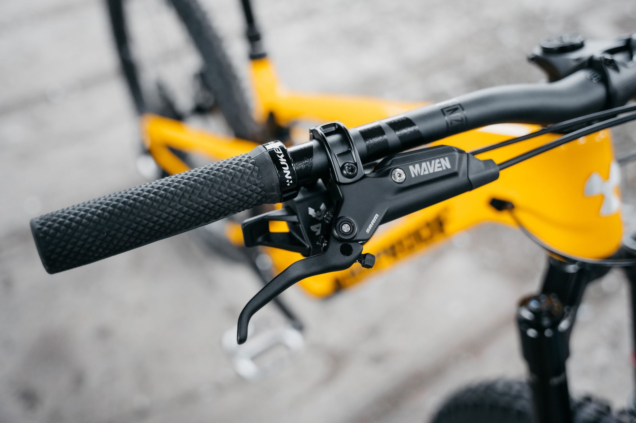 Close-up of bicycle handlebar with Maven brand logo on a blurred background