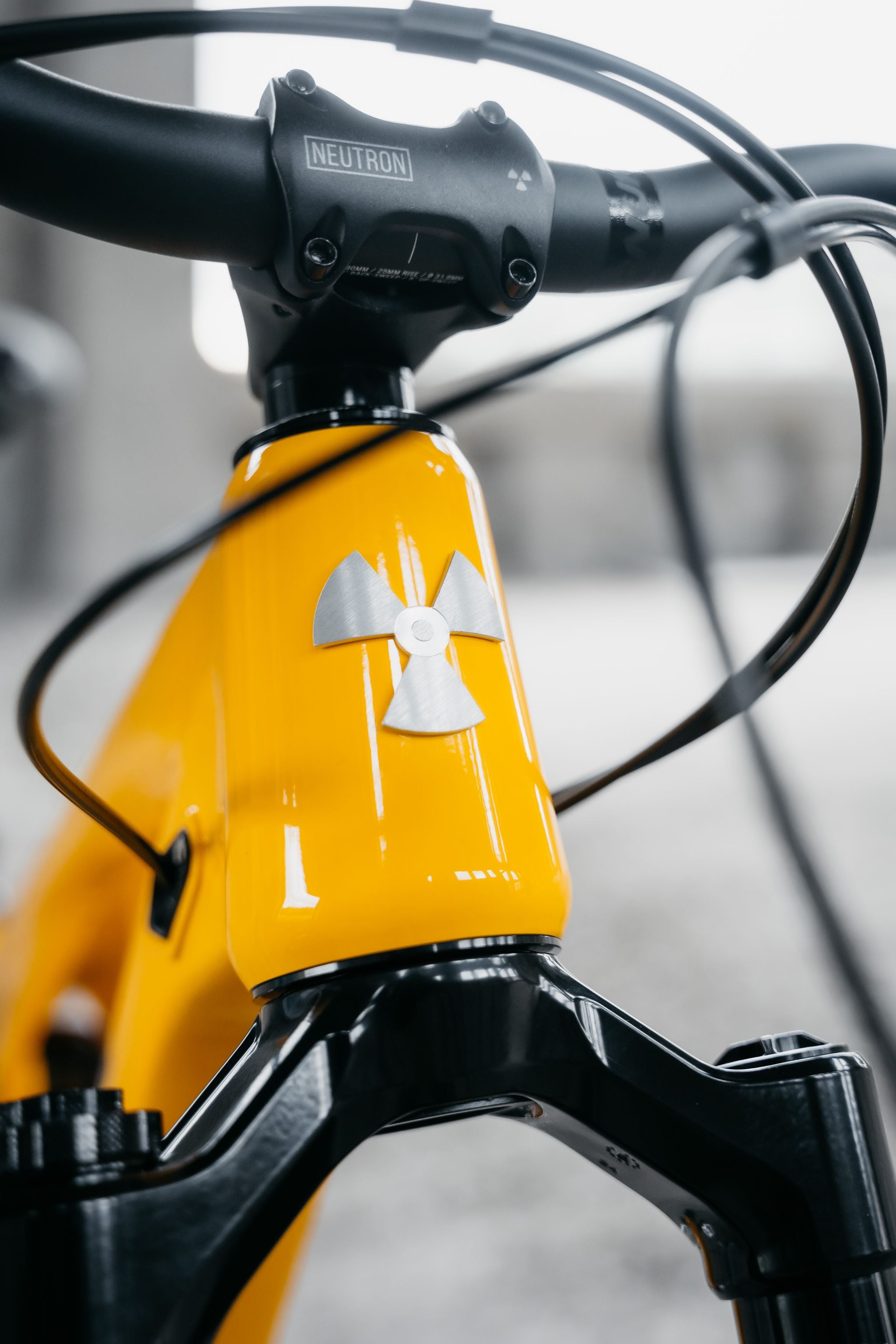 Close-up of a yellow bicycle with a black handlebar and visible brand logo.