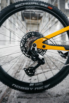 Close-up of a bicycle wheel with visible brand names on a blurred background